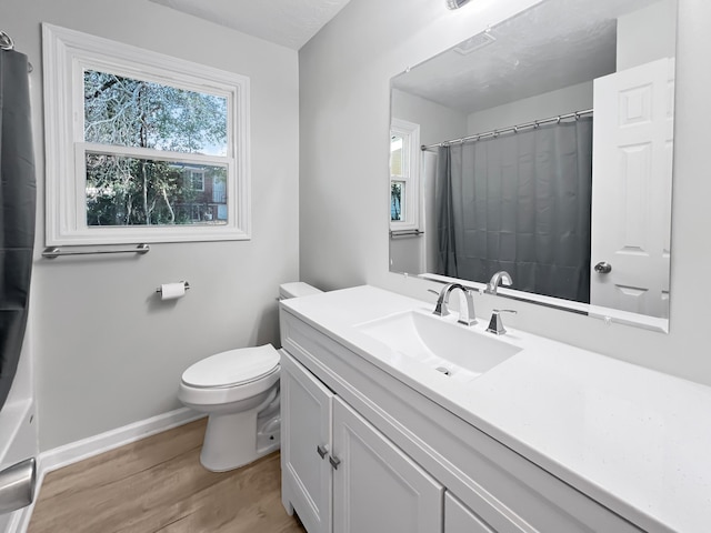 bathroom featuring vanity, toilet, wood-type flooring, and walk in shower