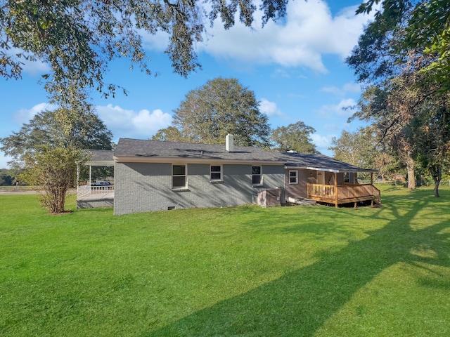 back of property featuring a lawn and a wooden deck