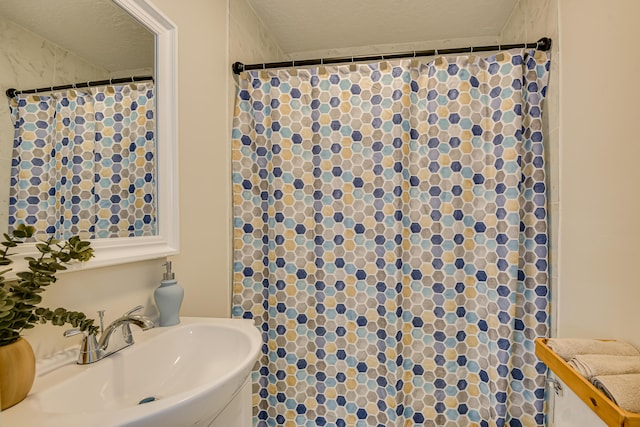 bathroom featuring a textured ceiling and sink