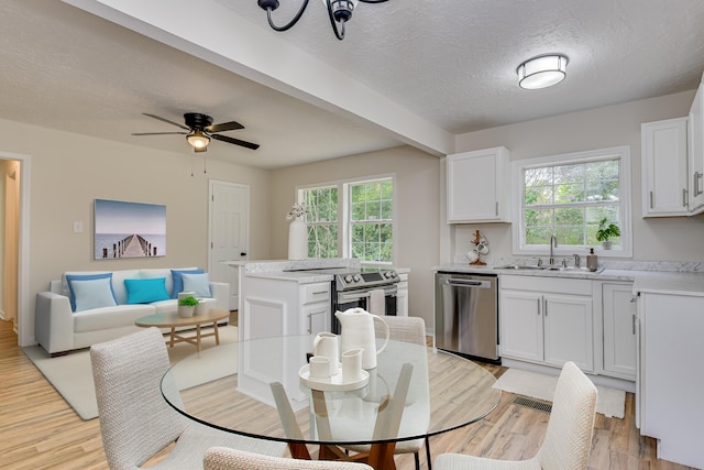 dining room featuring ceiling fan with notable chandelier, sink, light wood-type flooring, a textured ceiling, and beamed ceiling