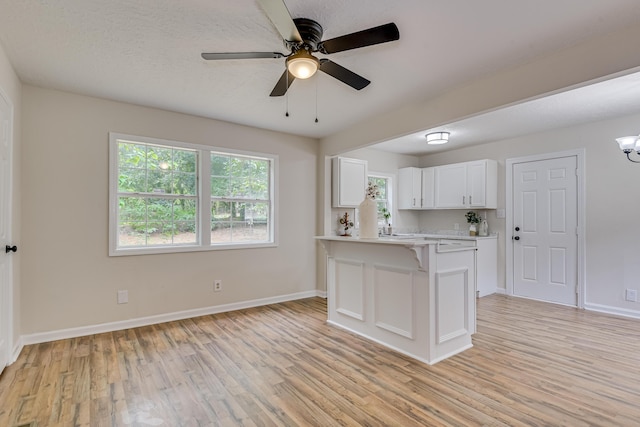 kitchen featuring ceiling fan with notable chandelier, white cabinetry, and light hardwood / wood-style flooring