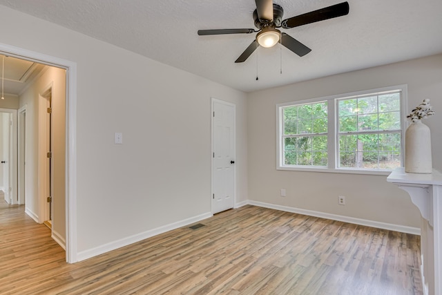 unfurnished room featuring a textured ceiling, light hardwood / wood-style floors, and ceiling fan