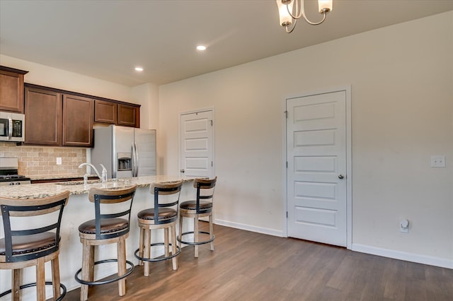 243 Quick Silver Ct, Graniteville, SC 29829 - kitchen featuring refrigerator with ice dispenser, stainless steel microwave, dark wood-style flooring, backsplash, and a kitchen bar