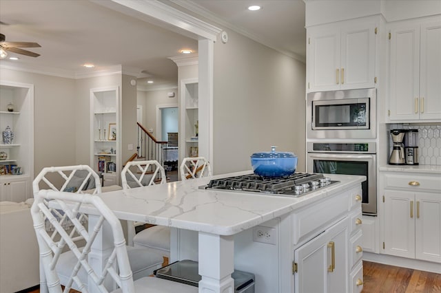 820 Barrett Ln, Augusta, GA 30909 - kitchen featuring appliances with stainless steel finishes, ceiling fan, a kitchen breakfast bar, a center island, and white cabinetry