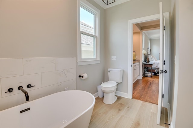 820 Barrett Ln, Augusta, GA 30909 - ensuite bathroom with a soaking tub, crown molding, toilet, and wood finished floors