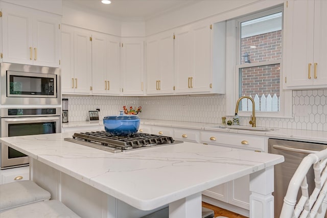 820 Barrett Ln, Augusta, GA 30909 - kitchen featuring appliances with stainless steel finishes, a sink, a kitchen bar, a center island, and white cabinets