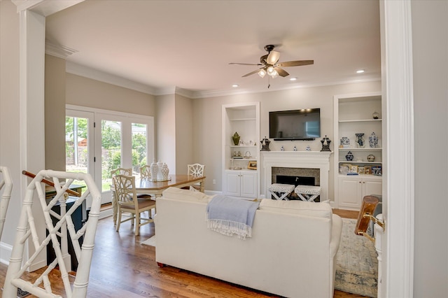 820 Barrett Ln, Augusta, GA 30909 - living area featuring ornamental molding, ceiling fan, wood finished floors, a fireplace, and built in shelves