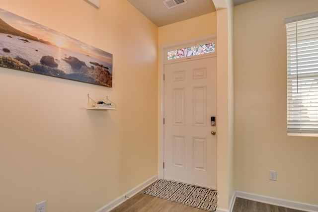 entrance foyer featuring baseboards, visible vents, and wood finished floors