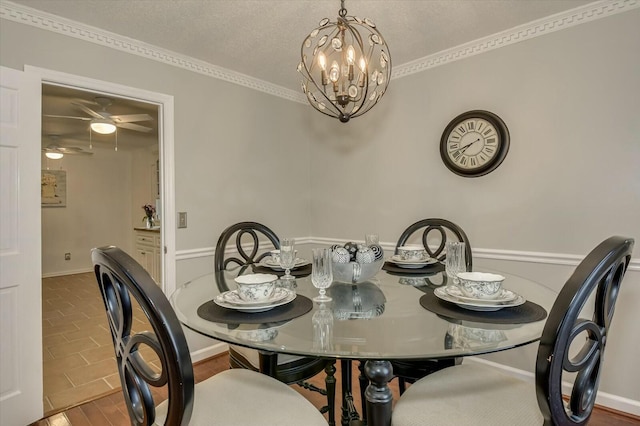 dining area featuring a textured ceiling, ornamental molding, hardwood / wood-style floors, and ceiling fan with notable chandelier