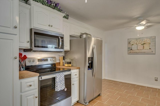 kitchen featuring ceiling fan, appliances with stainless steel finishes, white cabinets, and butcher block countertops