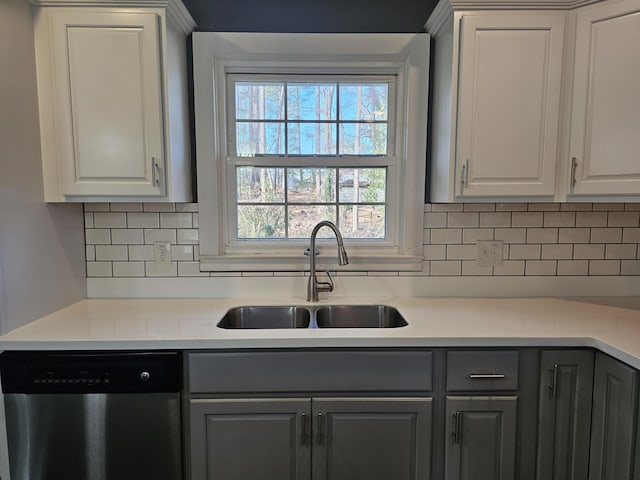 kitchen featuring tasteful backsplash, gray cabinetry, dishwasher, sink, and white cabinetry