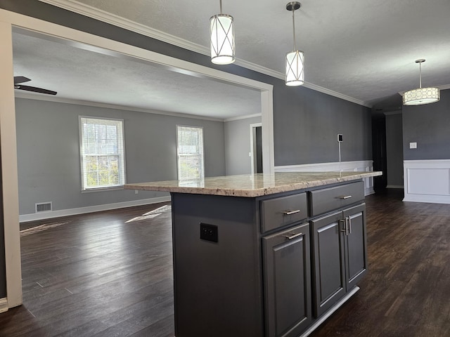 kitchen featuring dark wood-type flooring, a kitchen island, and decorative light fixtures