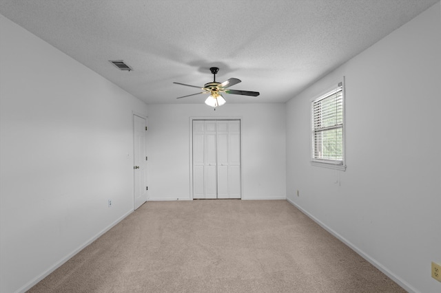 922 Windmill Ln, Evans, GA 30809 - unfurnished bedroom with light carpet, baseboards, a textured ceiling, a ceiling fan, and a closet
