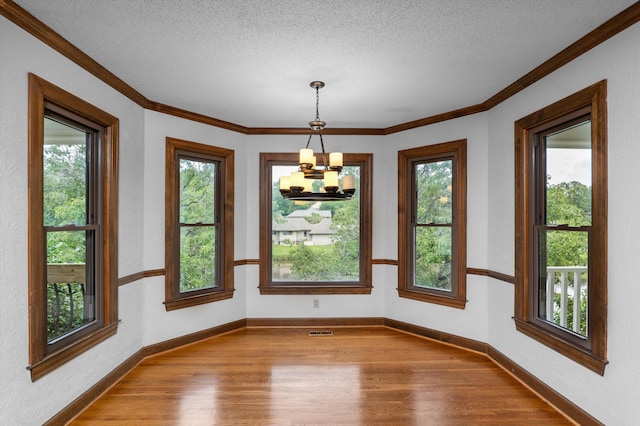 922 Windmill Ln, Evans, GA 30809 - empty room with wood finished floors, a chandelier, a textured ceiling, crown molding, and baseboards
