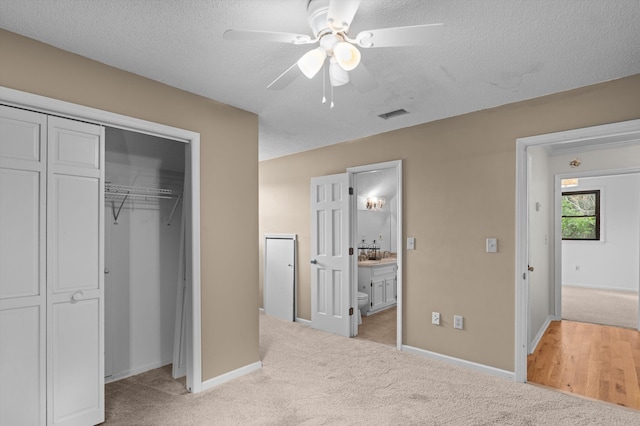 922 Windmill Ln, Evans, GA 30809 - unfurnished bedroom featuring light colored carpet, a closet, baseboards, ensuite bathroom, and a textured ceiling