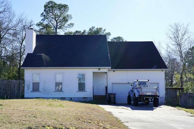 rear view of property with crawl space, driveway, a chimney, and fence