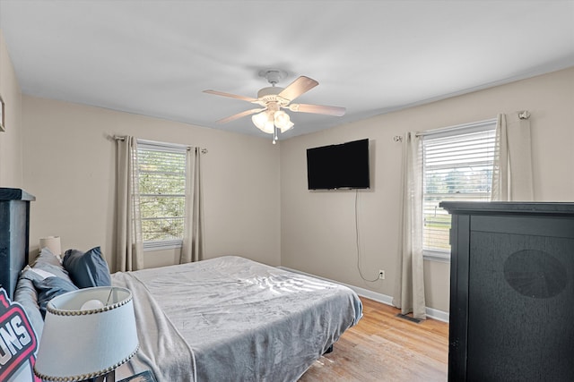 2872 Ga Highway 102, Wrens, GA 30833 - bedroom featuring ceiling fan, wood-type flooring, and multiple windows