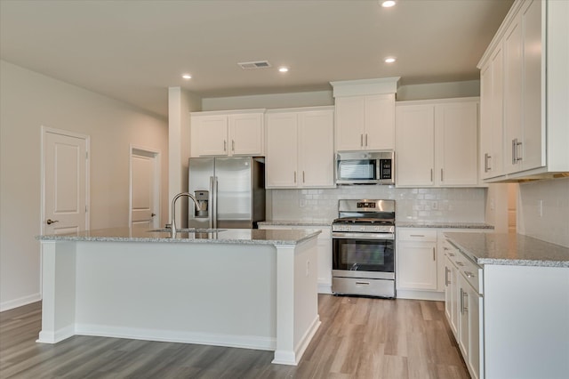 2015 Saylor Ln, Grovetown, GA 30813 - kitchen with stainless steel appliances, a sink, light wood-style flooring, tasteful backsplash, and white cabinets