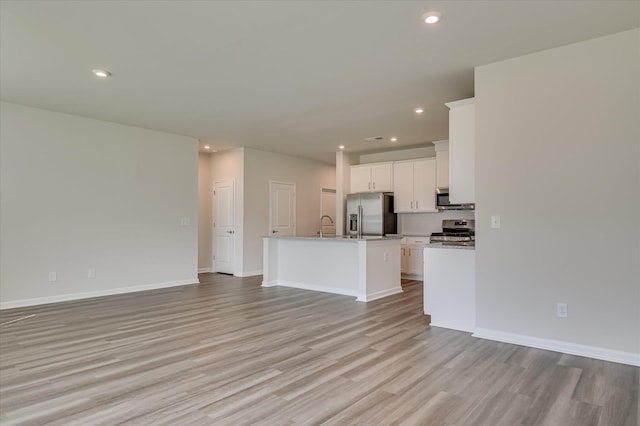 2015 Saylor Ln, Grovetown, GA 30813 - unfurnished living room with light wood-style floors, recessed lighting, baseboards, and a sink