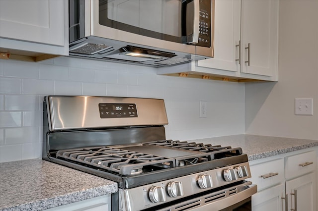 2015 Saylor Ln, Grovetown, GA 30813 - kitchen featuring appliances with stainless steel finishes, decorative backsplash, white cabinetry, and light stone countertops