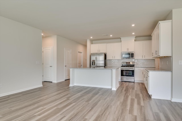 2015 Saylor Ln, Grovetown, GA 30813 - kitchen with stainless steel appliances, light wood-type flooring, backsplash, white cabinetry, and an island with sink
