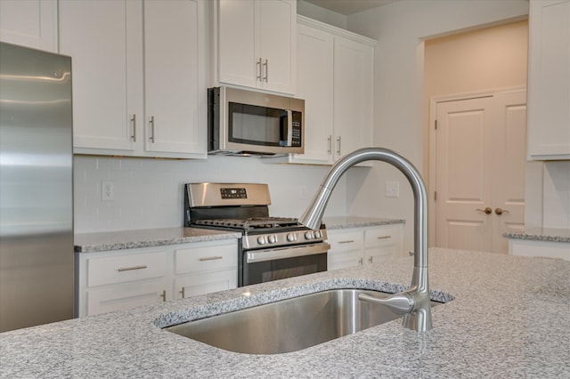 2015 Saylor Ln, Grovetown, GA 30813 - kitchen with appliances with stainless steel finishes, white cabinets, light stone countertops, backsplash, and a sink