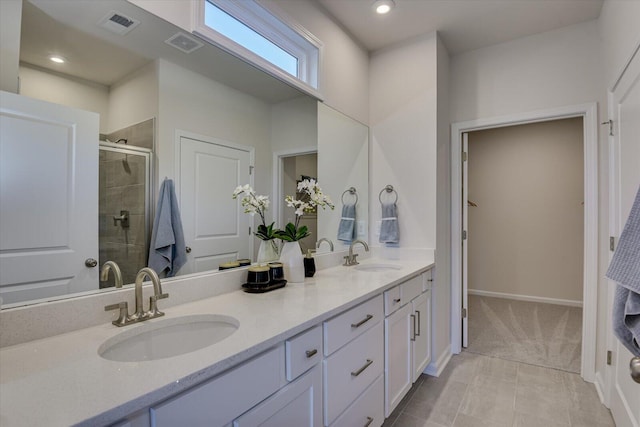 bathroom featuring a shower with shower door, vanity, and tile patterned flooring