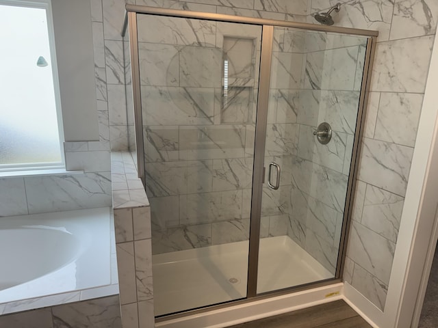 full bathroom featuring a stall shower and a bath