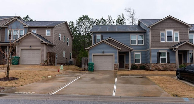 view of property with a garage, stone siding, cooling unit, and concrete driveway