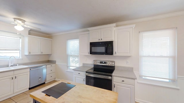 kitchen featuring a sink, ornamental molding, light countertops, white cabinets, and stainless steel appliances