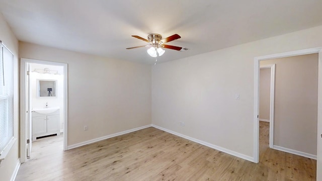 unfurnished bedroom with light wood-style floors, baseboards, and a sink