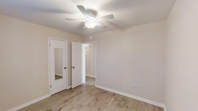 unfurnished room with baseboards, light wood-style floors, and ceiling fan