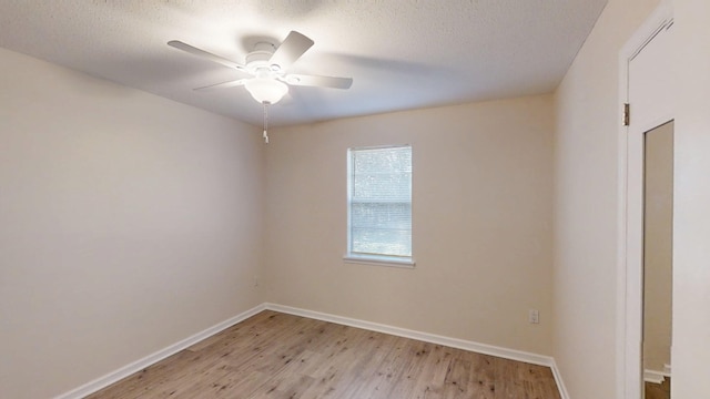 unfurnished room featuring light wood-style flooring, a textured ceiling, baseboards, and a ceiling fan