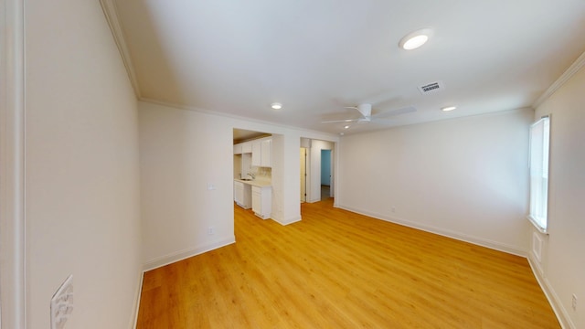 spare room with ornamental molding, ceiling fan, recessed lighting, light wood-style floors, and baseboards