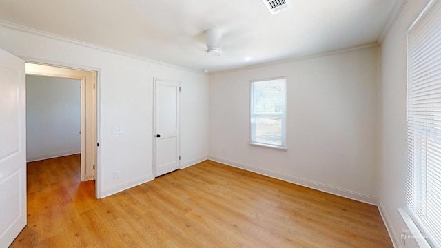 unfurnished bedroom featuring crown molding, light wood-style floors, and baseboards