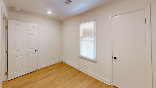 unfurnished room featuring crown molding, light wood-style floors, and baseboards