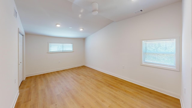 empty room with light wood-type flooring, vaulted ceiling, baseboards, and recessed lighting