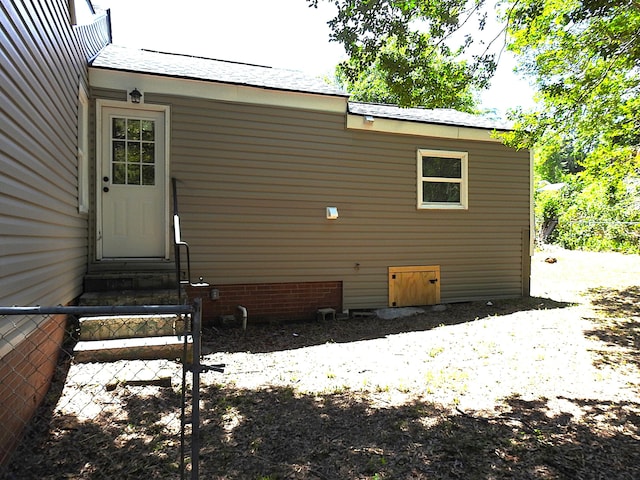 view of side of property featuring entry steps and fence