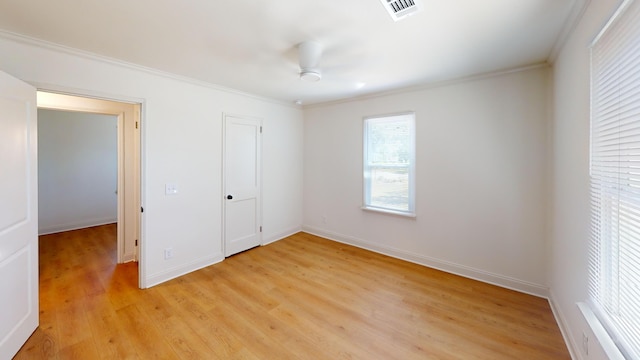 unfurnished bedroom with ornamental molding, light wood-type flooring, and baseboards