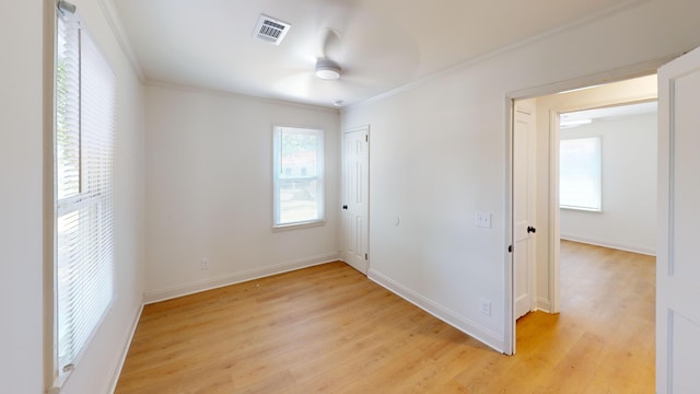 unfurnished room with ornamental molding, light wood finished floors, a ceiling fan, and baseboards