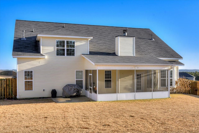 rear view of house with a yard and a sunroom