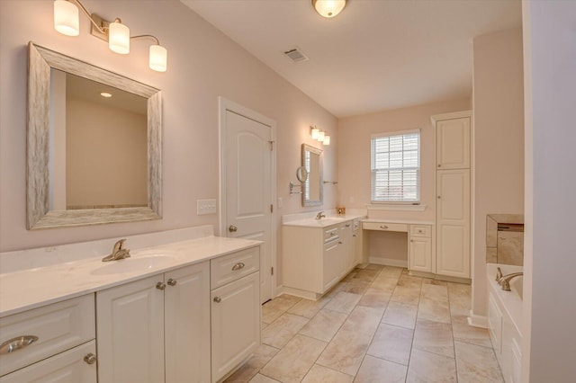 bathroom featuring vanity, tile patterned floors, and a bathtub