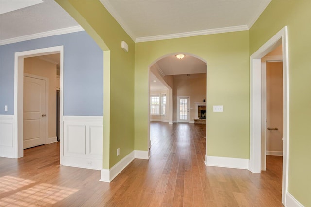 corridor featuring ornamental molding and light wood-type flooring