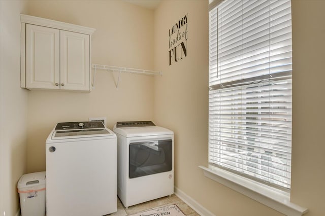 laundry area with cabinets, washer and dryer, and light tile patterned floors