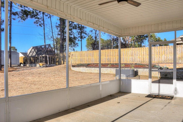 unfurnished sunroom with ceiling fan