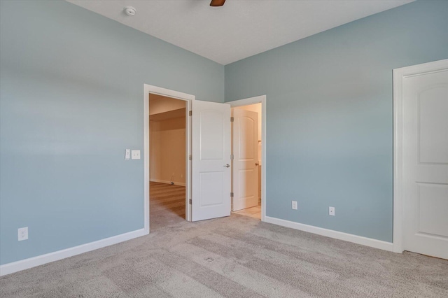 unfurnished bedroom featuring light colored carpet and ceiling fan