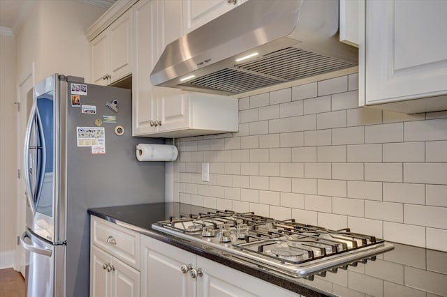 kitchen featuring white cabinets, extractor fan, appliances with stainless steel finishes, and backsplash