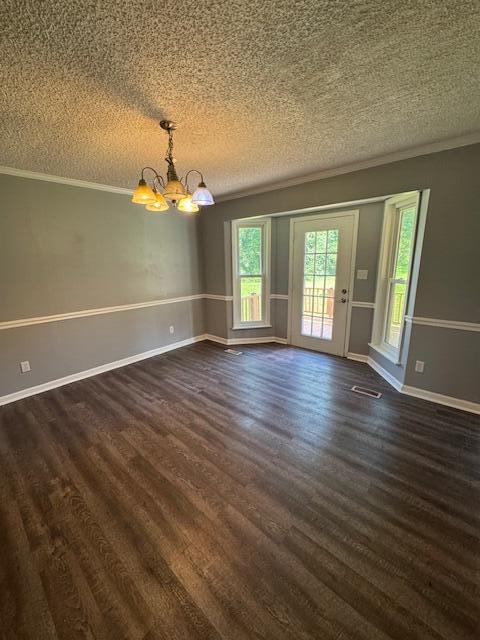6183 Columbia Rd, Appling, GA 30802 - spare room featuring a chandelier, crown molding, dark wood-type flooring, and a textured ceiling