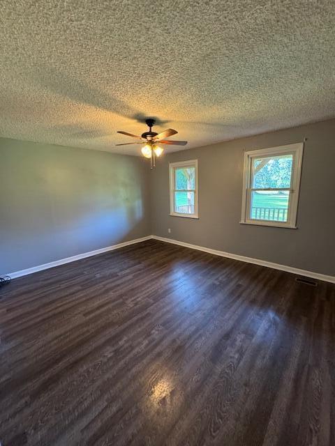 6183 Columbia Rd, Appling, GA 30802 - spare room with a textured ceiling, dark wood finished floors, and a ceiling fan