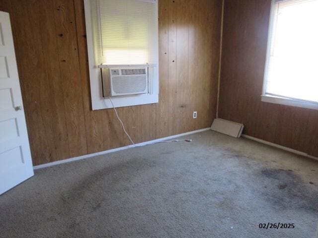 unfurnished room featuring carpet floors, cooling unit, and wooden walls